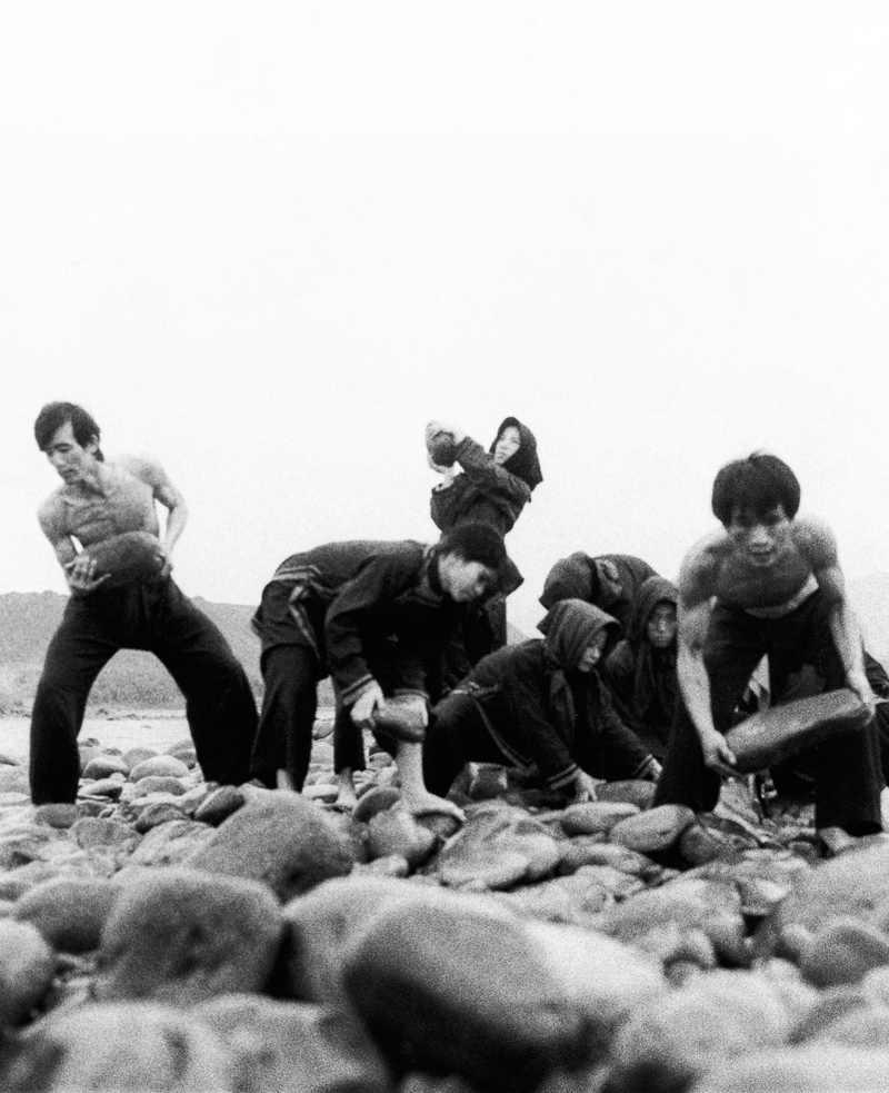 1978年林懷民在《薪傳》編舞期間，與雲門舞者到新店溪床上搬石頭訓練肢體。（攝影／霍榮齡；圖片提供／雲門文化藝術基金會）