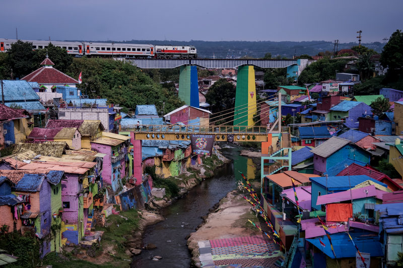 2022年8月26日，一列開往雅加達的火車穿過東爪哇瑪琅的一座橋，印尼政府正在將貧民窟和人口密集的城市地區開發成新的旅遊景點。（攝影／NurPhoto via Getty Images／Aman Rochman）
