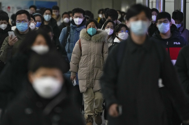 動態清零持續3年後，中國迅速「與病毒共存」。圖為2022年12月20日，在北京上午通勤的高峰時段，戴口罩的民眾在兩個地鐵站之間的人行道上行走。（攝影／AP Photo／Andy Wong／達志影像）