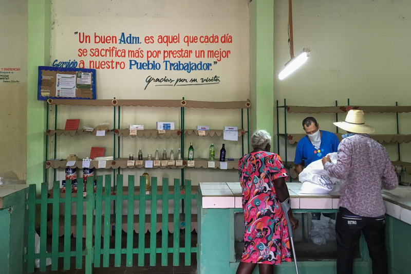 使用糧票和CUP購物的商店；牆上的標語寫著：「一個好的政府，每天都會做出更多犧牲，為勞動人民提供更好的服務。」（攝影／李易安）