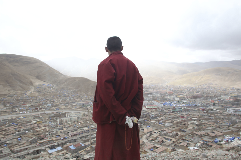 2010年4月19日，一名西藏僧侶在玉樹高處看著因地震毀壞的城市。（攝影／Corbis via Getty Images／Jie Zhao）
