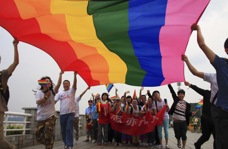 自2000年初開始，中國公民社會和大學在推動性少數權益方面曾迎來蓬勃景象，彩虹旗一度在校園內外飄揚。圖為2013年5月17日，湖南長沙舉行的國際反恐同日遊行，活動人士高舉彩虹旗，橫幅上寫著「同志亦凡人」。（攝影／Stringer／REUTERS）