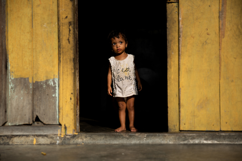 馬來西亞檳城的一位羅興亞小女孩站在家門，穿著一件印有法語「C’est la vie」（這就是生活）的衣服。（攝影／Arnaud Finistre）