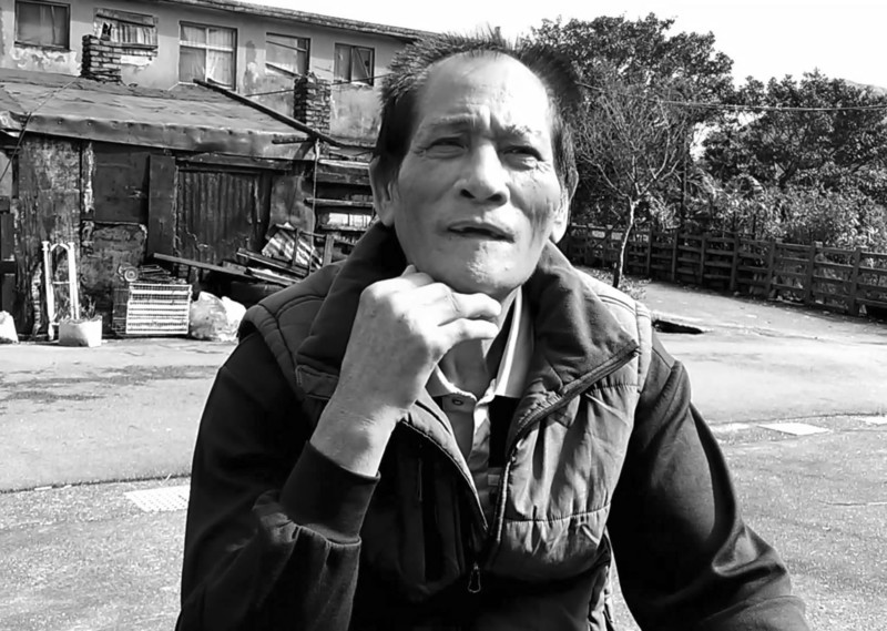 2019年,方金德指著1986年原住民礦工相聚用餐的照片,說圖中背對鏡頭的身影就是自己。(攝影/朱健炫)