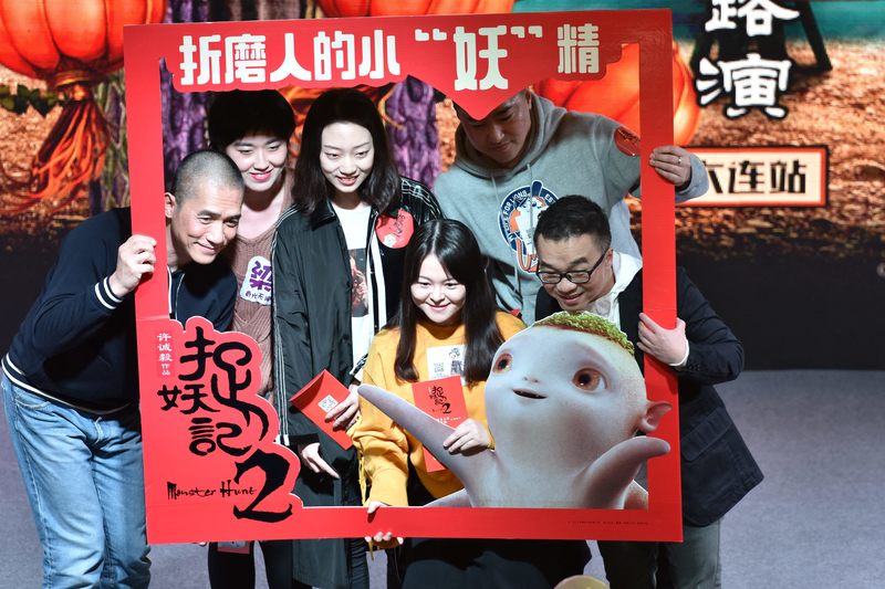 中港合拍片《捉妖記2》在中國票房高達22億人民幣。圖為出生香港的導演許誠毅（右）、主演的香港演員梁朝偉（左）與中國觀眾合照。（攝影／Imaginechina via AFP／Wang xizeng）