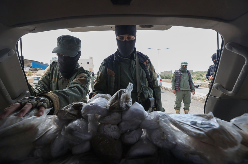 為支撐龐大戰爭支出，阿薩德政府傾國家之力生產廉價安非他命類毒品。圖為2022年4月10日，沙姆解放組織的士兵展示了他們在阿勒頗西部村落一處檢查哨查獲的毒品。（攝影／AFP／Omar haj kadour）