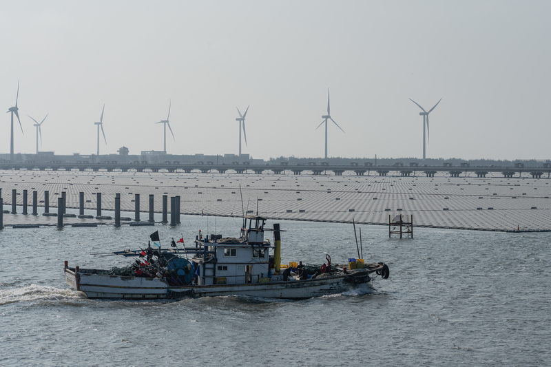 彰濱工業區線西水道，返港的漁船與太陽能光電板。（攝影／許震唐）
