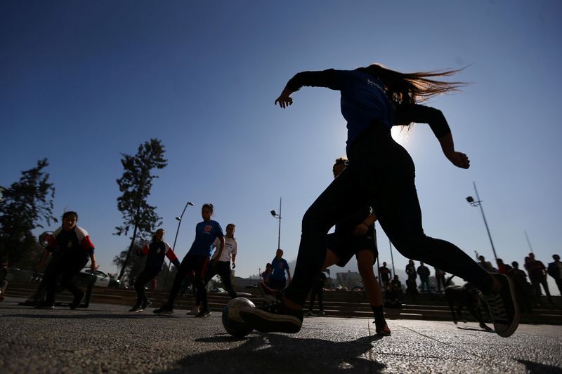 2018年在智利聖地亞哥舉行一場抗議活動中，女性以踢足球表達訴求，要求結束體育界的性別歧視和性別暴力。（攝影／Ivan Alvarado／REUTERS）