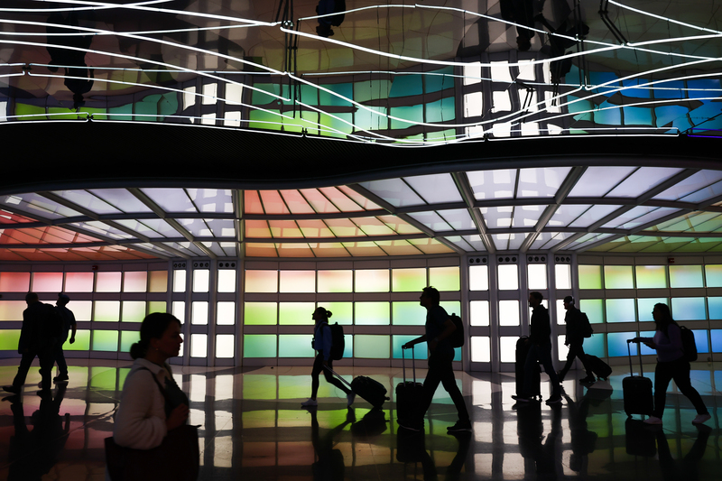 2022年，旅客行走在芝加哥歐海爾國際機場的霓虹裝置「明日航站」（Terminal for Tomorrow）前。（攝影／Getty Images via NurPhoto／Jakub Porzycki）