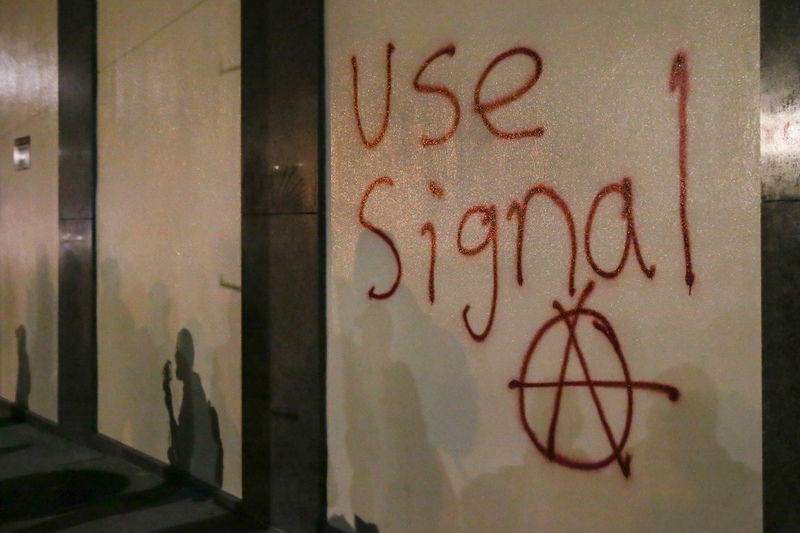 2017年2月1日，英國備受爭議的極右翼政治評論員米羅・雅諾波魯斯（Milo Yiannopoulos）預定在美國加州大學柏克萊分校發表演說，引發民眾上街示威，一面牆上的塗鴉呼籲參與者使用高度加密的通訊軟體Signal。（攝影／Getty Images／Elijah Nouvelage）