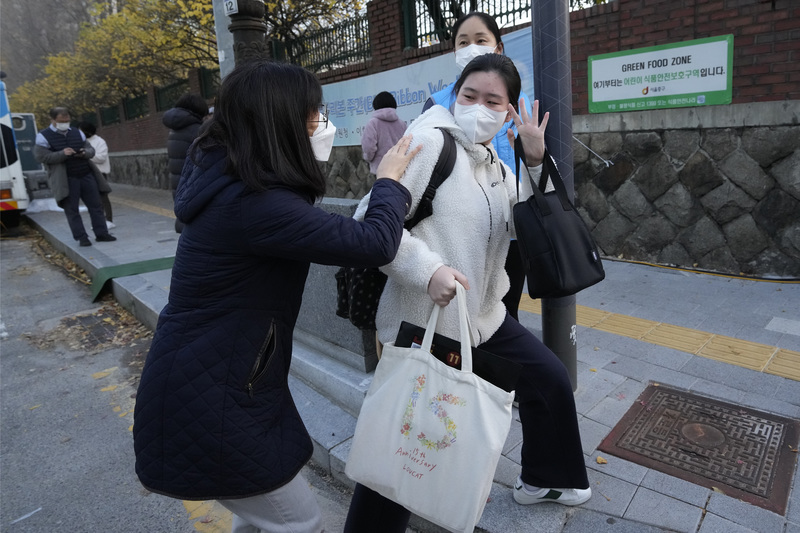 2022年11月17日，韓國首爾一名學生在進入高中參加高考前向母親揮手。（攝影／AP Photo／Ahn Young-joon）