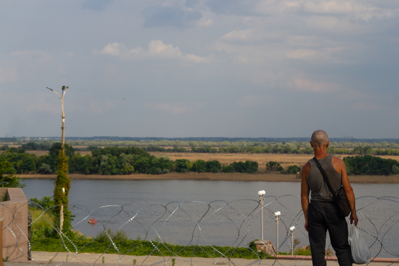一名男子在赫爾松的榮耀公園眺望聶伯河對岸。（攝影／曹雨昕）