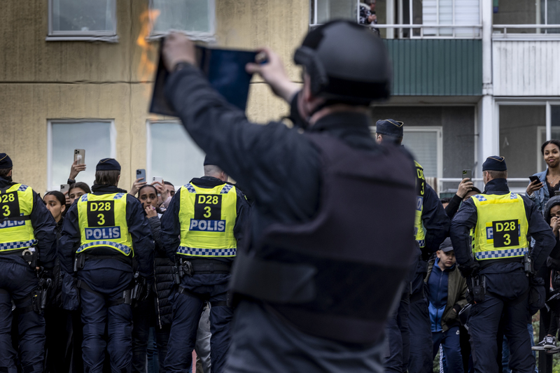 2022年5月14日，帕魯丹（Rasmus Paludan，前者）在競選期間，於警察的保護下，在瑞典斯德哥爾摩的穆斯林社區公開焚燒《古蘭經》，作為選舉活動。（攝影／Getty Images／Jonas Gratzer）
