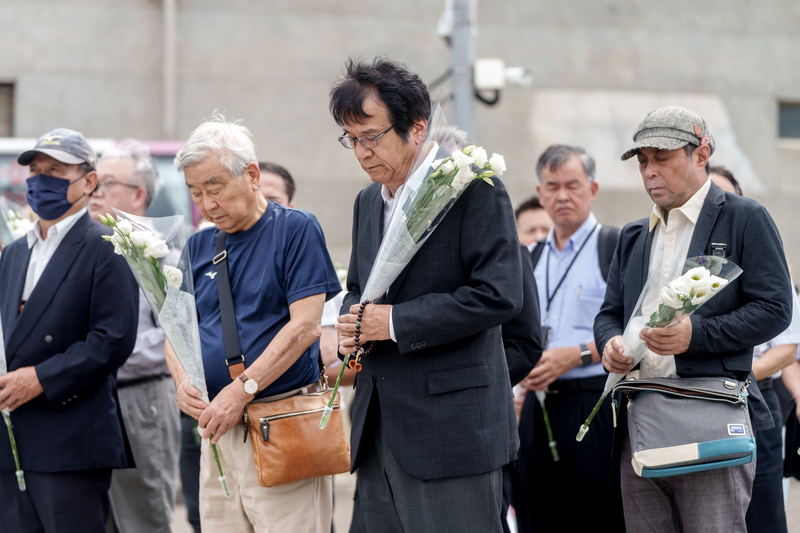 JR西日本改革的重要人物福知山事故家屬淺野彌三一（左2）、關西大學名譽教授安部誠治（左3）以及《軌道：福知山線出軌事故，改變JR西日本的奮鬥》作者松本創（右1）來台訪問，於台鐵富岡機廠保存的太魯閣事故車廂前獻花致哀。（攝影／黃世澤）