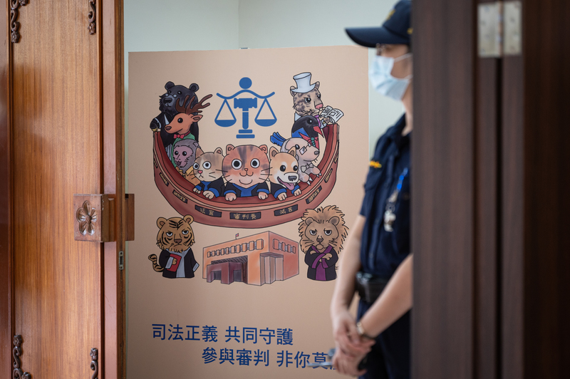 台北地方法院寶慶院區法庭外的法警與國民法官宣傳立牌。（攝影／林彥廷）