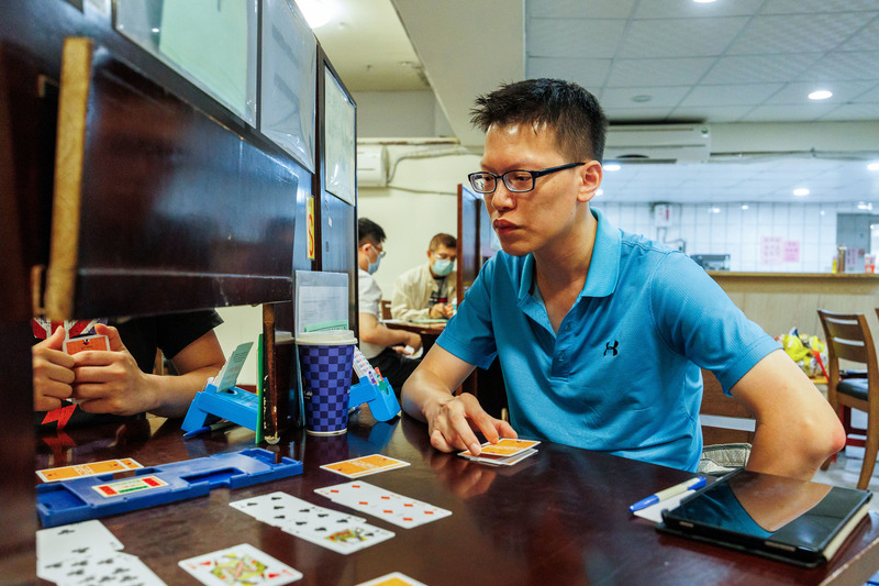 橋藝國手周哲民在比賽時審慎地思考、計算牌張組合。為了能專注參與杭州亞運，他決定辭去工作。（攝影／鄭宇辰）