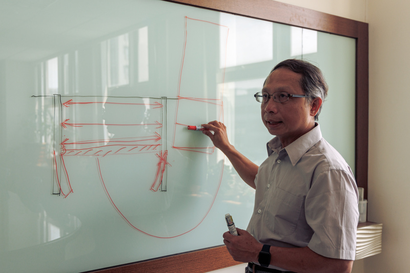 大地工程技師公會理事長施志鴻在白板上畫出此次基泰大直案件中的現場狀況，同時解釋事故的成因。（攝影／鄭宇辰）