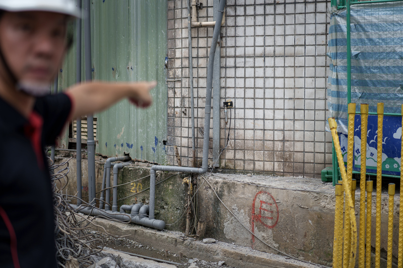 9月11～15日，台北市針對184處工地進行緊急體檢。圖為大地工程技師公會理事吳維揚前往萬隆站旁的工地進行查驗，他手指的方向是可以監測鄰房裂縫有無擴大的「裂縫計」。（攝影／黃世澤）