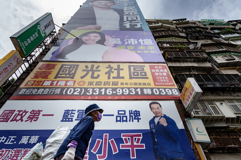 圖為台北市萬華區一處大樓外牆，最下方的是國民黨立法委員參選人鍾小平的初選廣告；中間為民進黨立法委員參選人吳沛憶廣告；最上方是台灣民眾黨陳耀宇在去年市議員初選的廣告。（攝影／黃世澤）