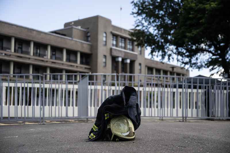 2023年9月28日，一位消防員的消防衣與頭盔被放置於行政院的大門前。（攝影／楊子磊）