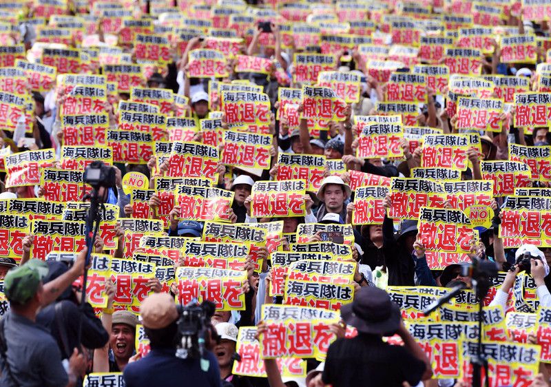 2016年6月19日,在沖繩市區的反美軍基地抗議集會上,居民舉著「撤走海軍陸戰隊」的標語牌。(攝影/The Yomiuri Shimbun via AFP/ Manabu Kato)