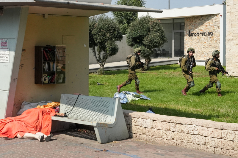 2023年10月7日，以色列士兵在鄰近加薩的斯德洛特行動，街道上仍有在哈馬斯的襲擊中喪生的平民遺體。（攝影／AFP／Baz Ratner）