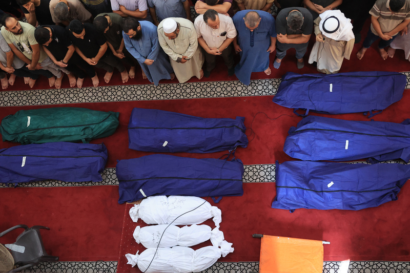 2023年10月8日，在以色列對加薩走廊南部的拉法市發動空襲後，人們聚集在一間清真寺為喪生的市民禱告。（攝影／AFP／Said Khatib）