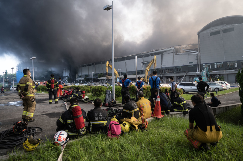 2023年9月23日上午，消防員於燃燒中的屏東明揚國際科技工廠旁暫時休息。（攝影／楊子磊）