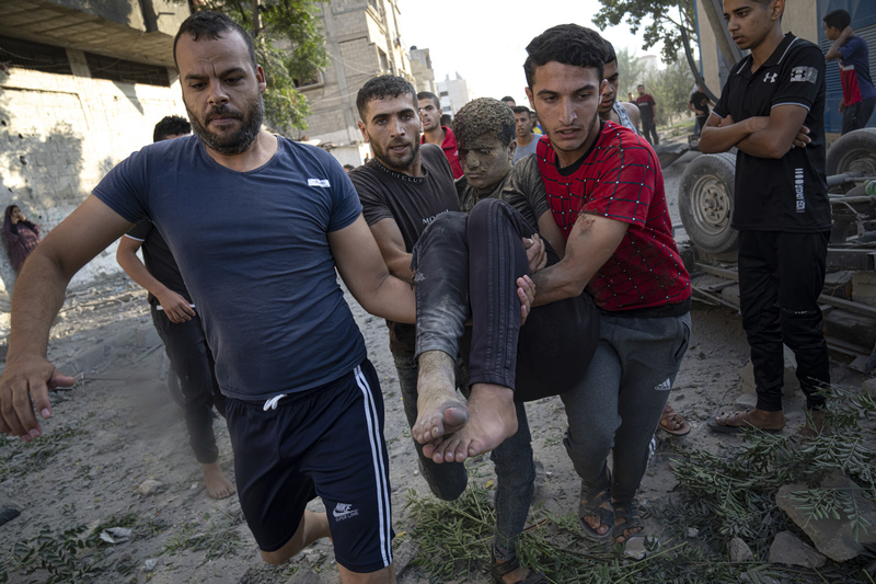 2023年10月16日，加薩走廊汗尤尼斯（Khan Younis），巴勒斯坦民眾抬著一名在以色列空襲中受傷的人。（攝影／AP Photo／Fatima Shbair）