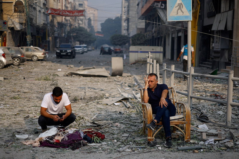 2023年10月8日，巴勒斯坦人坐在加薩一條被以色列轟炸後，布滿廢墟的街道上。（攝影／REUTERS／Mohammed Salem）