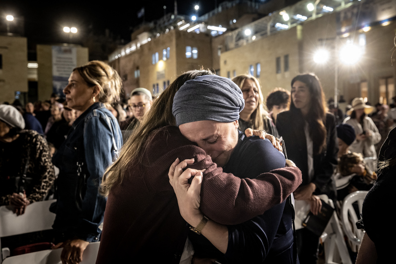 耶路撒冷城內，民眾於廣場上的悼念儀式上相互擁抱。（攝影／AFP／FADEL SENNA）