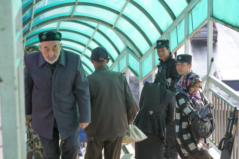 2016年10月10日，幾名軍事巡邏人員在新疆烏魯木齊的公車站入口處進行安全檢查。（圖片來源／Getty Images）