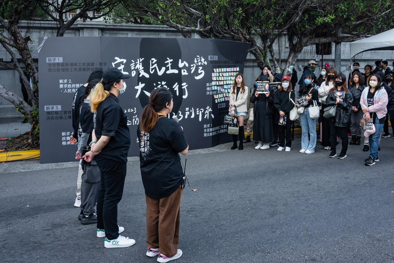 12月3日，「反對增加新移工國」活動的主要籌辦人（左側）在活動接近尾聲時，向現場聚集的工作人員與支持者發表感言。（攝影／陳曉威）