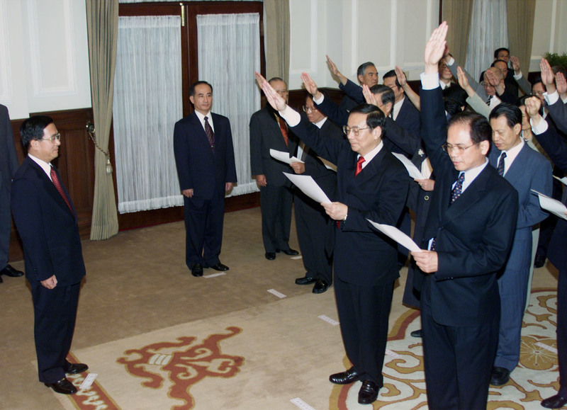 2000年首位民進黨籍總統陳水扁(左)上任後,任命國民黨籍閣揆唐飛,但遭遇重重阻礙;139天後改由民進黨的張俊雄(圖中紅領帶者)接任閣揆。(攝影/REUTERS/Simon Kwong/達志影像)