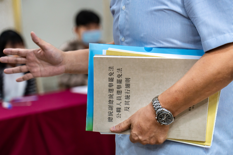 朱磊擔心登記參選立委會被選務人員阻擋，還特地帶了選舉法規到現場以備不時之需。不過當天只是登記收件，從參選登記一開始到最後，都沒有選務人員提到朱磊可能不符參選資格一事。（攝影／陳曉威）
