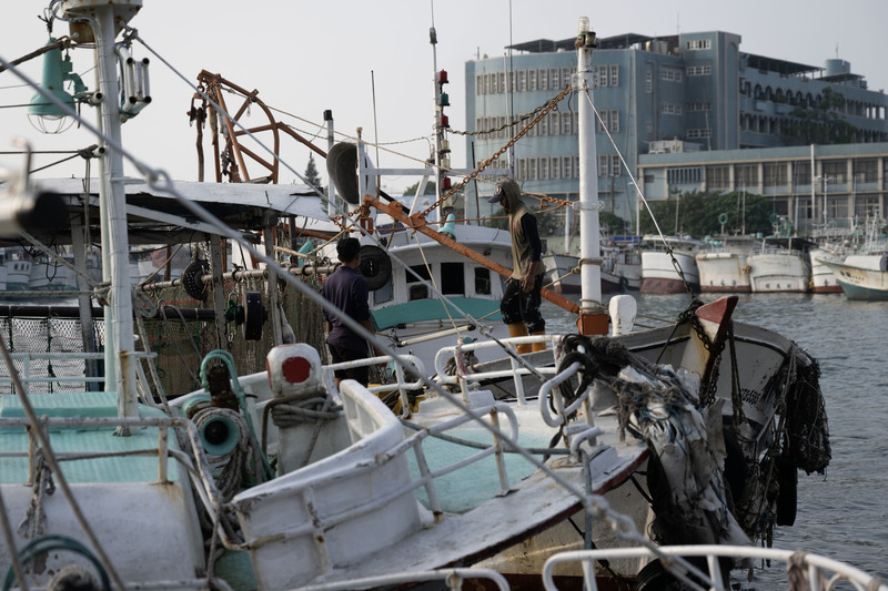 在屏東東港的港區內停泊的漁船，與船上的漁工。（攝影／楊子磊）