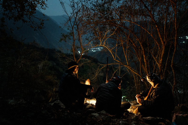 南投信義鄉，布農族青年獵人於深夜上山打獵，休息等待同伴會合。（攝影／黃世澤）