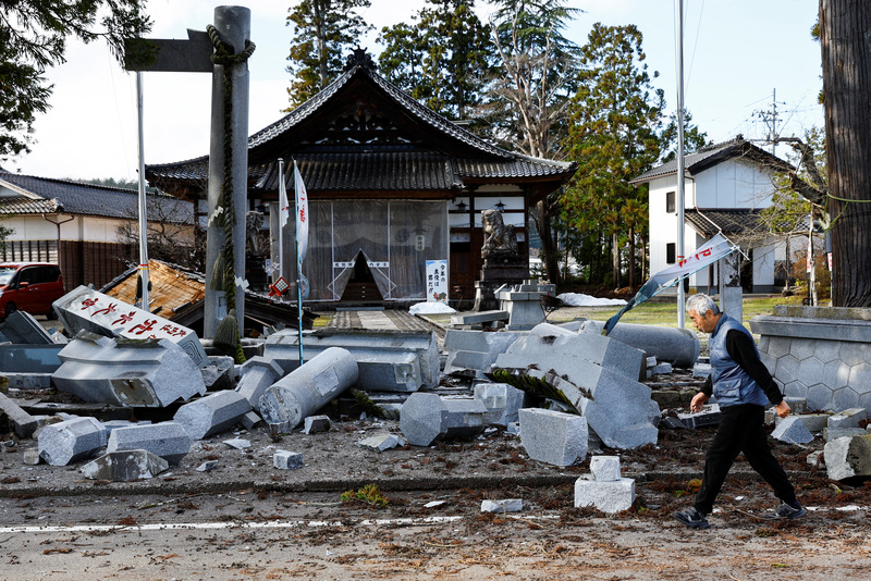 能登半島東部的穴水町，一位民眾經過震後受損的神社。（攝影／REUTERS／Kim Kyung-Hoon）