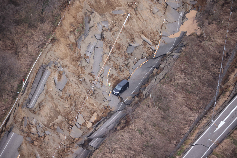 能登半島中央的七尾市，一輛轎車陷於因強震崩毀的高速公路上。（攝影／The Yomiuri Shimbun via AFP／Yomiuri／Toshikazu Sato）