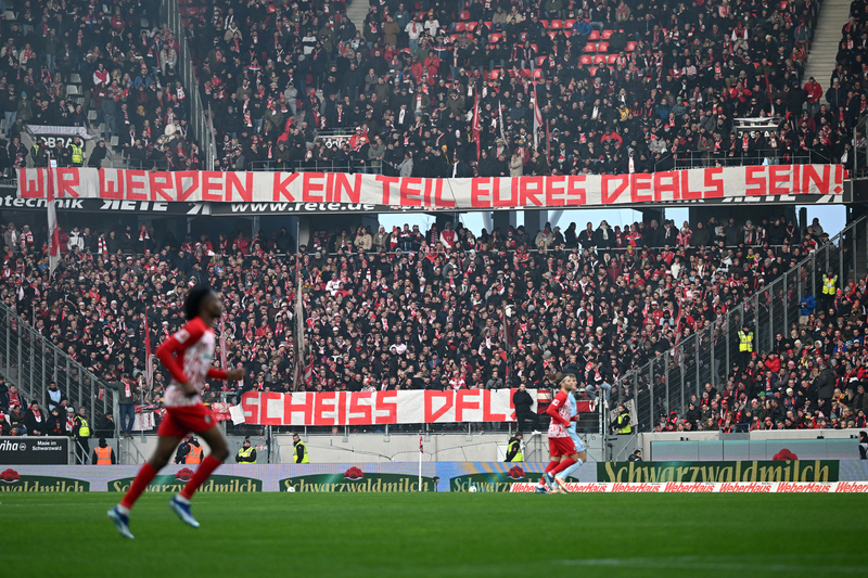 2023年12月17日，德國球迷在歐洲公園體育場舉行的德甲聯賽──弗萊堡（SC Freiburg）與科隆（1. FC Köln） 比賽期間，揭開寫有「我們不會成為您交易的一部分」（Wir werden kein Teil Eures Deals sein）的大型橫幅，抗議聯盟修改球隊的投資規定。（攝影／Getty Images／Christian Kaspar-Bartke）