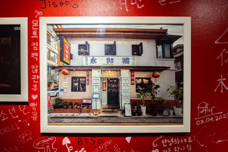 台北「永和樓」的牆面上，掛著位於首爾的「永和樓」照片。（攝影／陳曉威）
