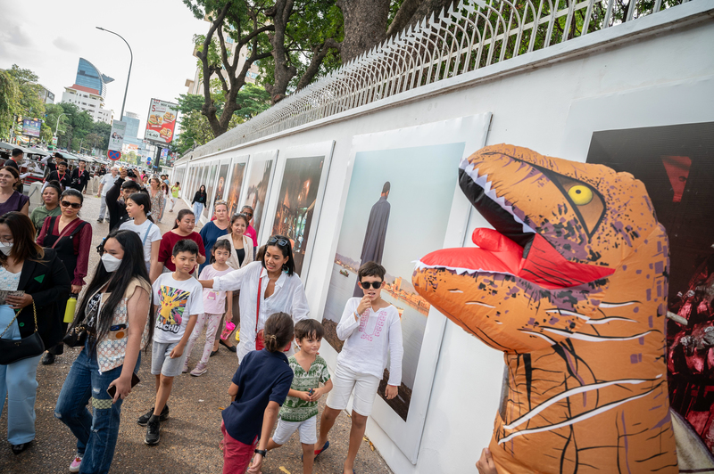 金邊攝影節開幕首週經常可看到恐龍玩偶裝人員穿梭在展覽之間，反映該國年輕群眾的喜好與活潑氣息。（攝影／黃郁修）