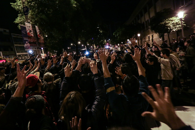 2014年3月24日凌晨，行政院旁中山北路上的民眾高舉雙手，要求警方停止前進，最後仍遭警方強制驅離。（攝影/楊子磊）