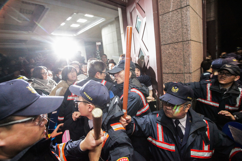 2014年3月23日晚間，進入行政院建築物內的反服貿民眾與警察在行政院正門幾度推擠衝突，後者終以優勢警力封鎖大門、管制進出。（攝影／楊子磊）