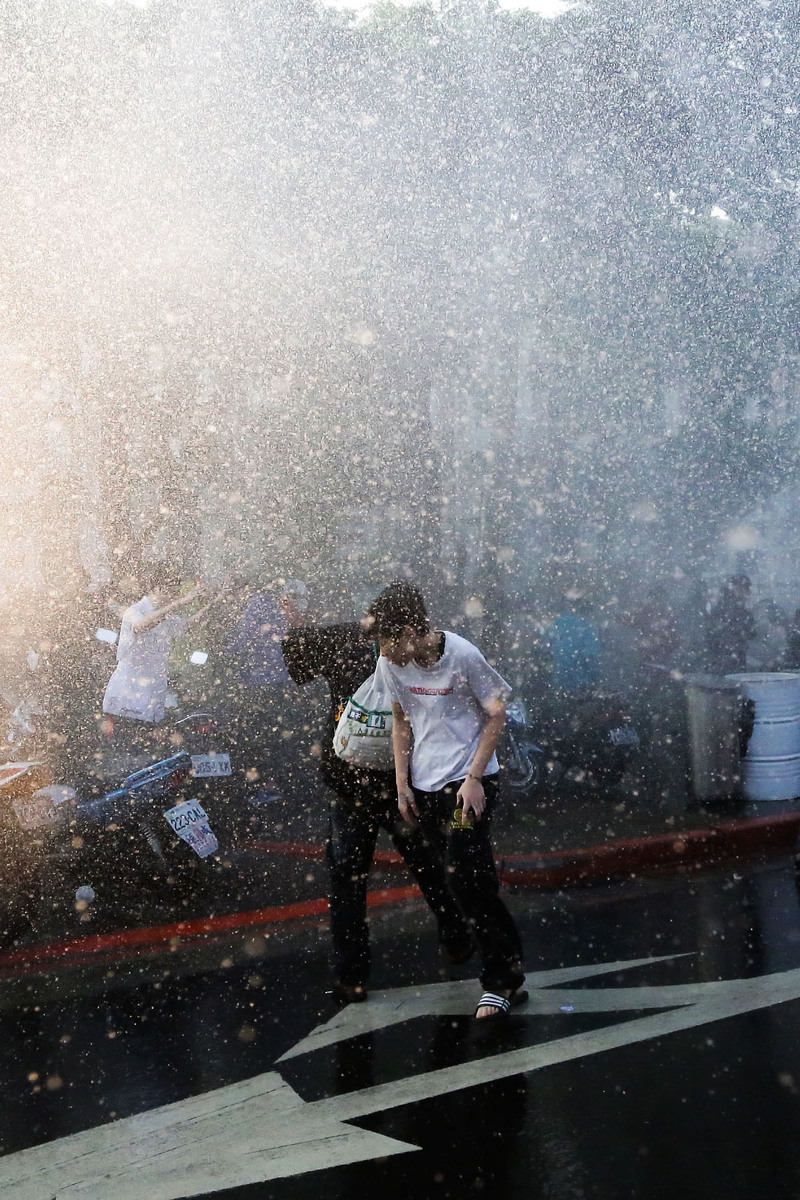 2014年3月24日清晨，監察院前的民眾遭到警方鎮暴水車水柱攻擊。（攝影／楊子磊）