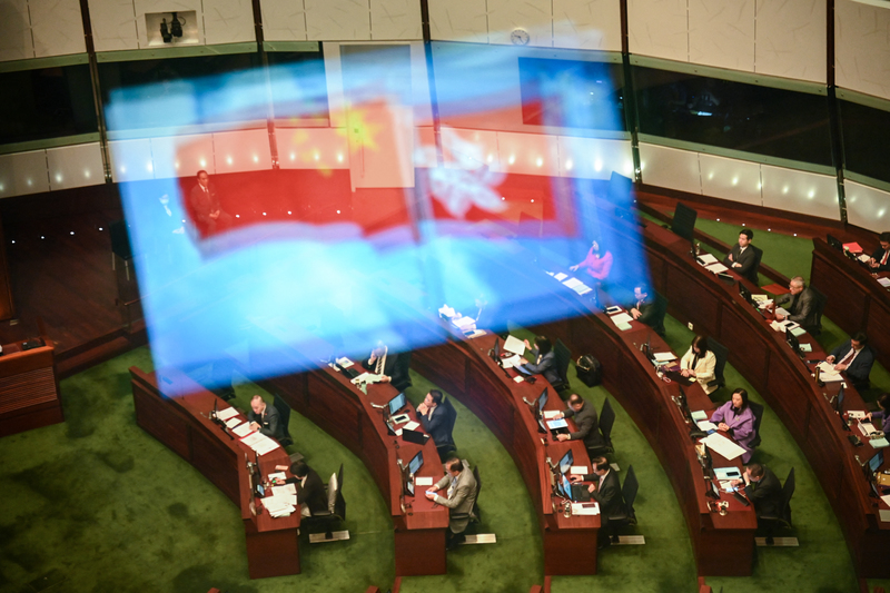2024年3月19日下午，香港立法會進行《基本法》23條立法二讀時鏡面反射的旗幟。（攝影／AFP／Peter PARKS）