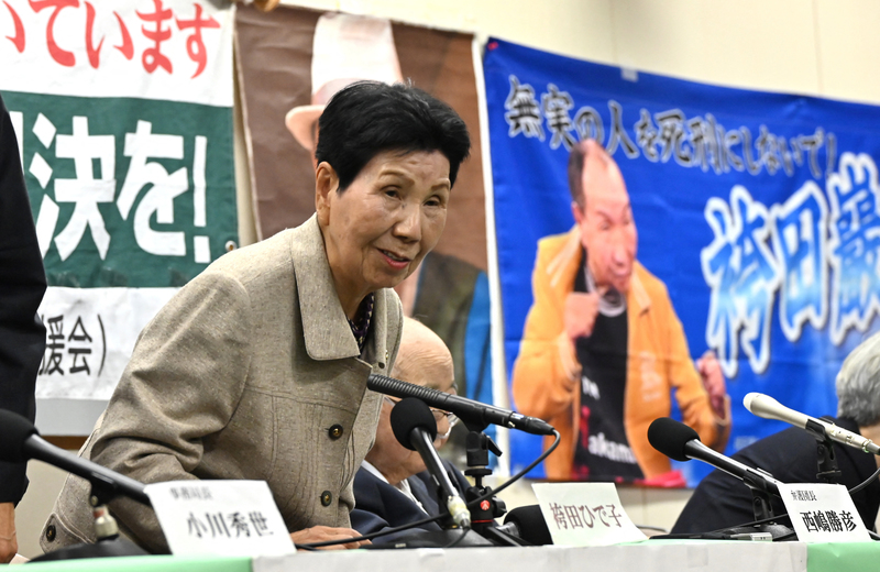 袴田嚴的姊姊袴田秀子，現年91歲的她為弟弟平反奔走將近60年，在2023年10月27日靜岡縣重審庭審後的新聞發布會上發言。背後的海報則是世上被關最久的死囚袴田嚴的照片。（攝影／Kaname Muto／The Yomiuri Shimbun via AFP)