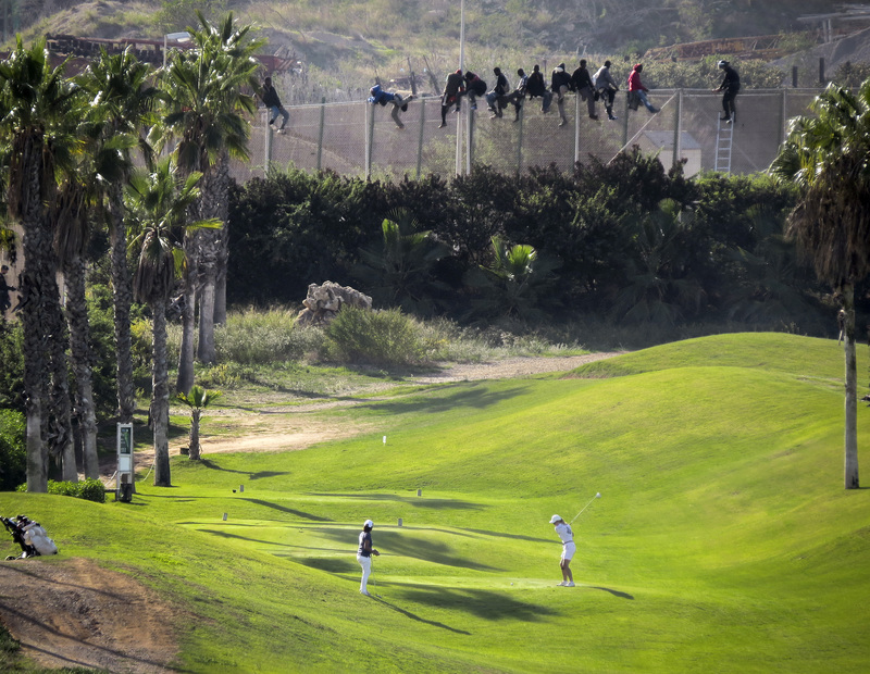 2014年10月，來自非洲的祕密（非法）移民者，試圖翻越位於摩洛哥的西班牙飛地美利雅（Melilla）一處高爾夫球場邊界圍籬。（攝影／REUTERS／Jose Palazon／達志影像）
