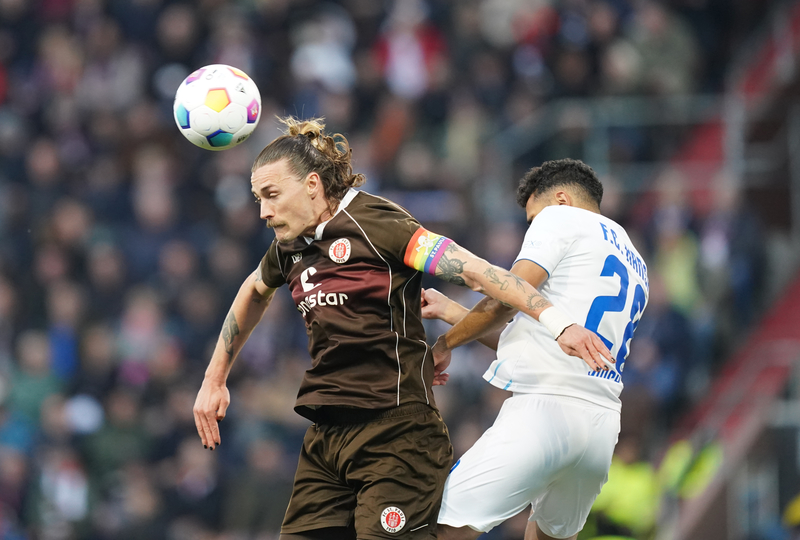 2024年4月26日，聖保利足球隊與漢莎羅斯托克（FC Hansa Rostock）的比賽中，聖保利的隊長傑克遜．歐文（Jackson Irvine，左）正在爭奪球權。（攝影／picture alliance via Getty Images／Marcus Brandt）