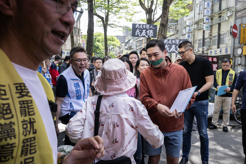 2025年4月16日上午，罷免吳思瑤團體「地動刪瑤」與國民黨主席朱立倫（左）前往北投自強早市掃街收集連署書，罷團召集人賴苡任（右2）全程以綠色膠帶貼嘴，抗議日前罷綠團體涉不實連署遭檢調搜查。（攝影／楊子磊）
